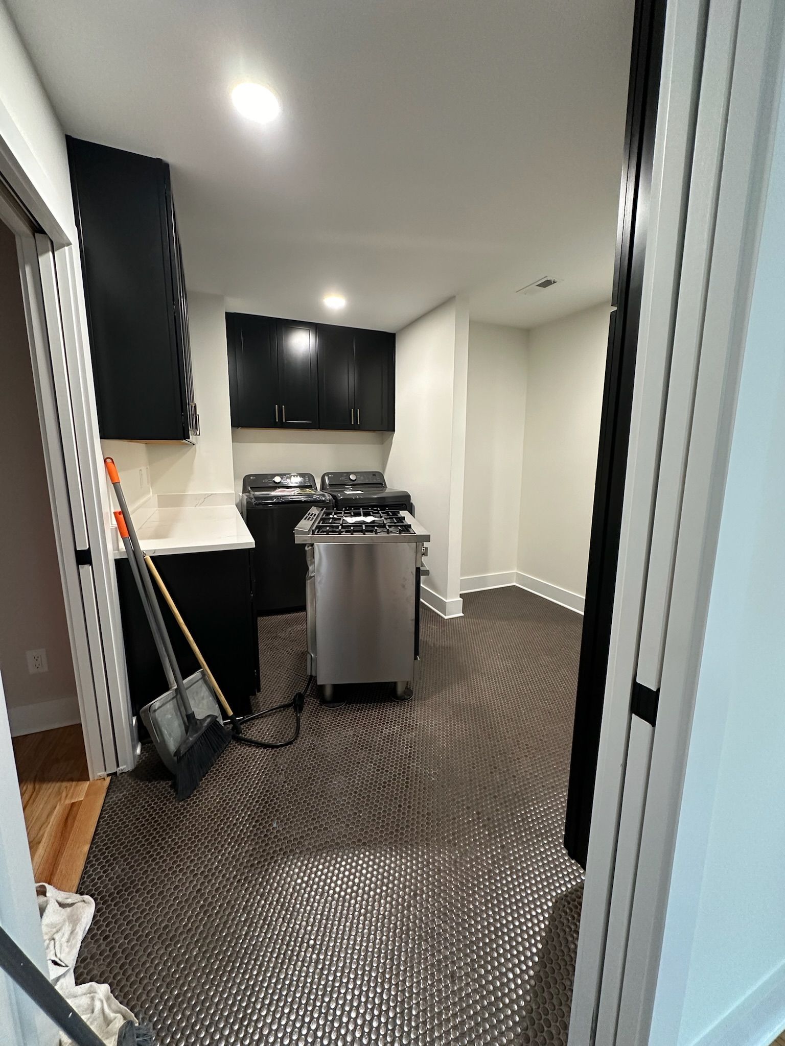 A kitchen with stainless steel appliances and black cabinets is being remodeled.