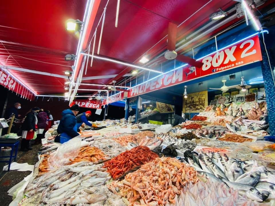 Una stanza con tavoli e sedie e un dipinto sul muro