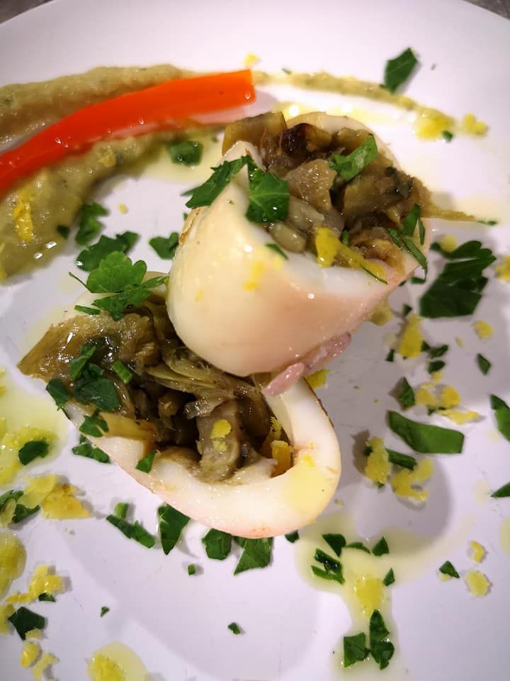 Un piatto bianco con sopra tagliatelle e carne su un tavolo di legno