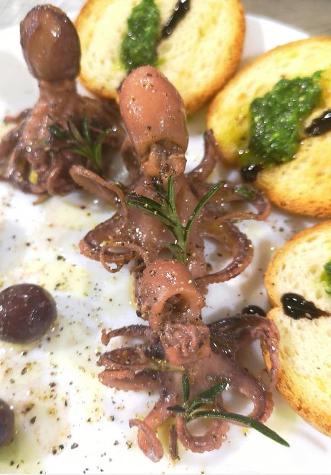 Un piatto di cibo con una ciotola di insalata e una ciotola di ali di pollo