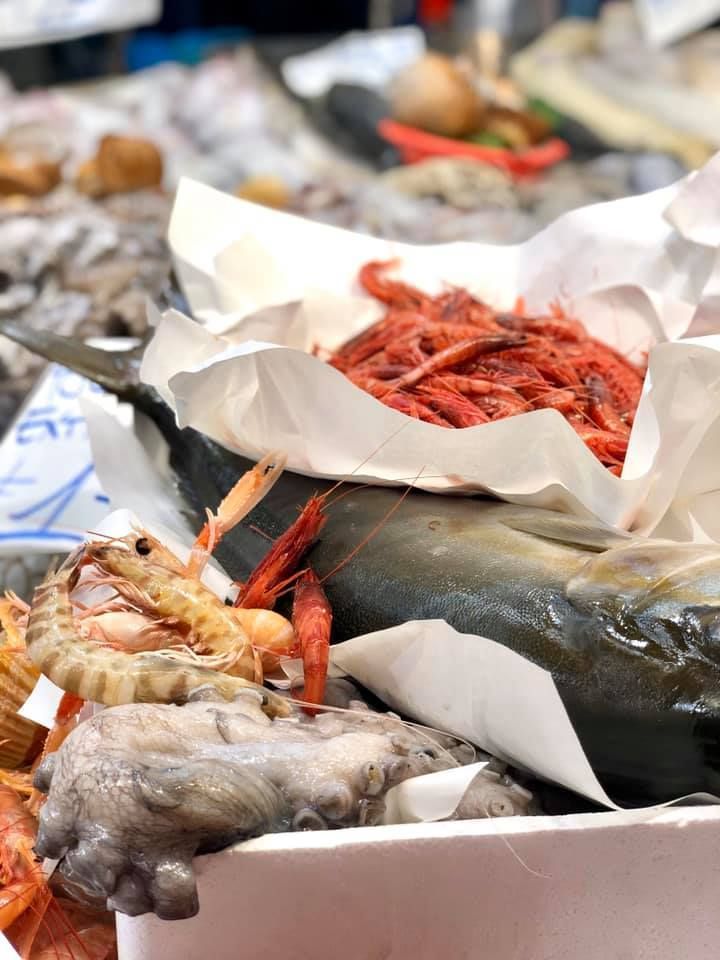 Un piatto bianco con pesce e verdure su un tavolo
