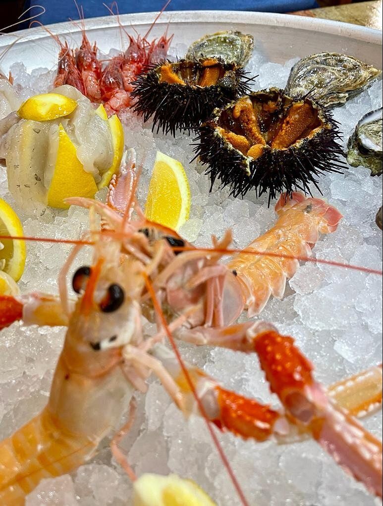 Un piatto bianco con pesce e verdure su un tavolo