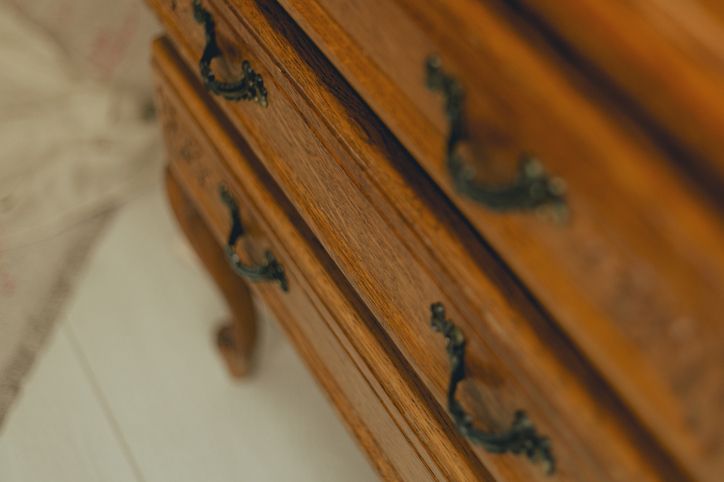 Cassettiera in legno con due cassetti a vista e maniglie in metallo scuro.