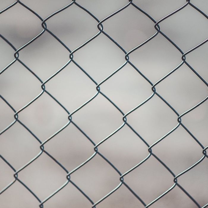 A close up of a chain link fence on a white background.