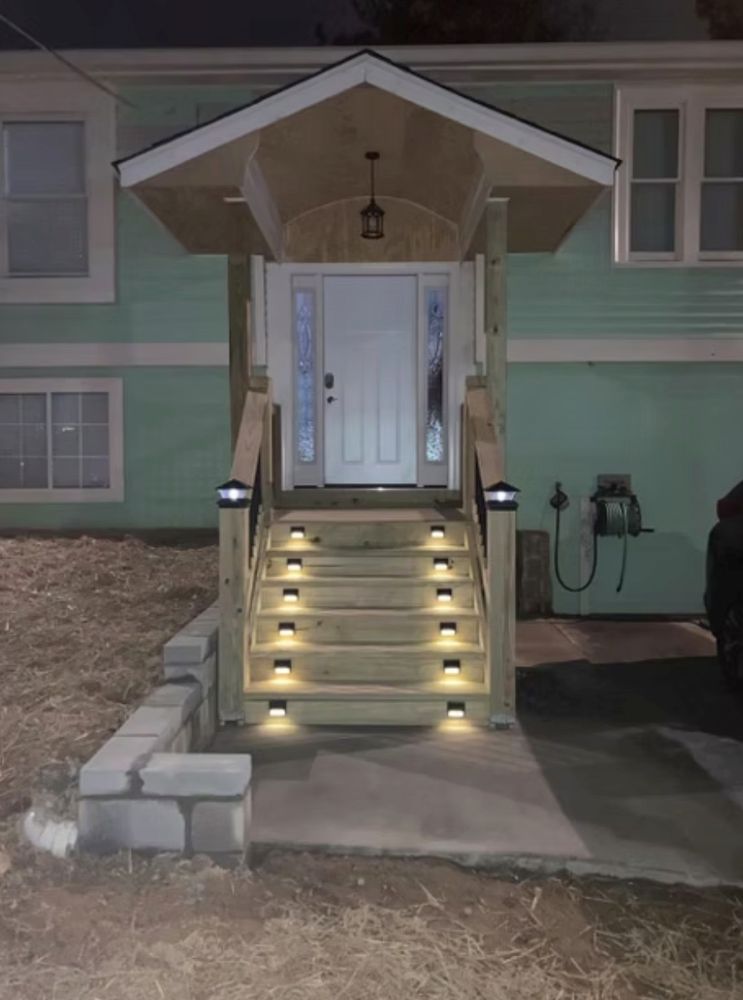 Woman in straw hat smiles, holding wine glass near a lake.