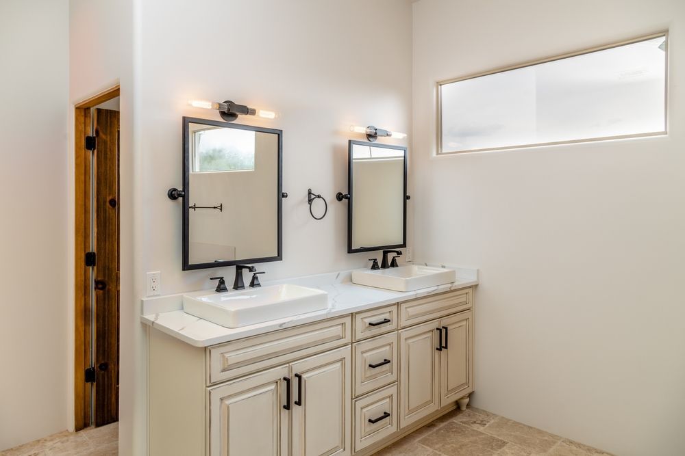 Woman in straw hat smiles, holding wine glass near a lake.