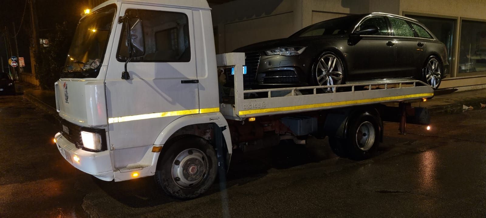 Un carro attrezzi trasporta un'auto sul retro.