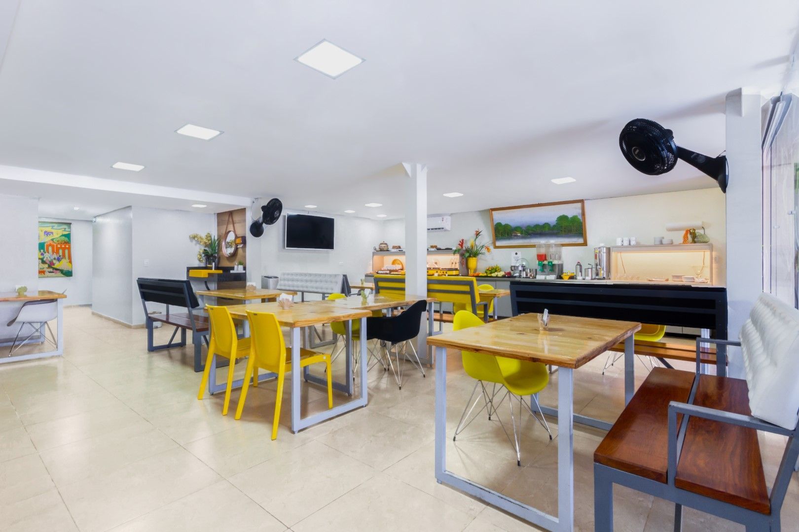 Uma sala grande com mesas e cadeiras.