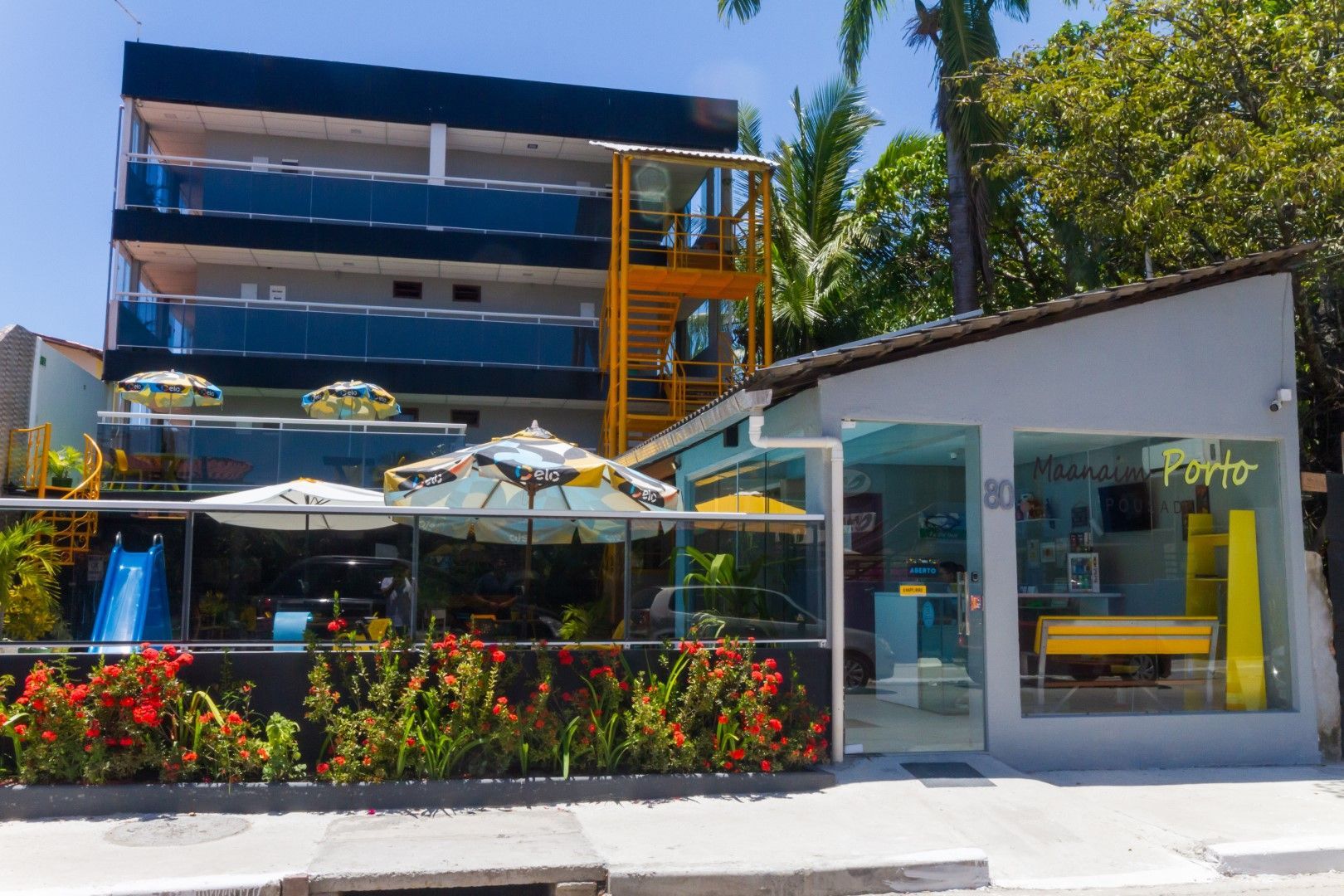 Um prédio com guarda-chuvas e flores na frente