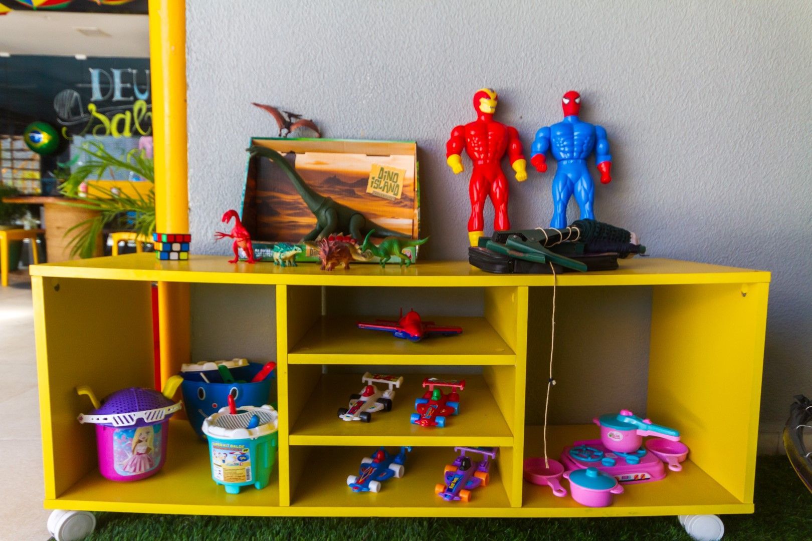 Uma prateleira amarela com um monte de brinquedos nela