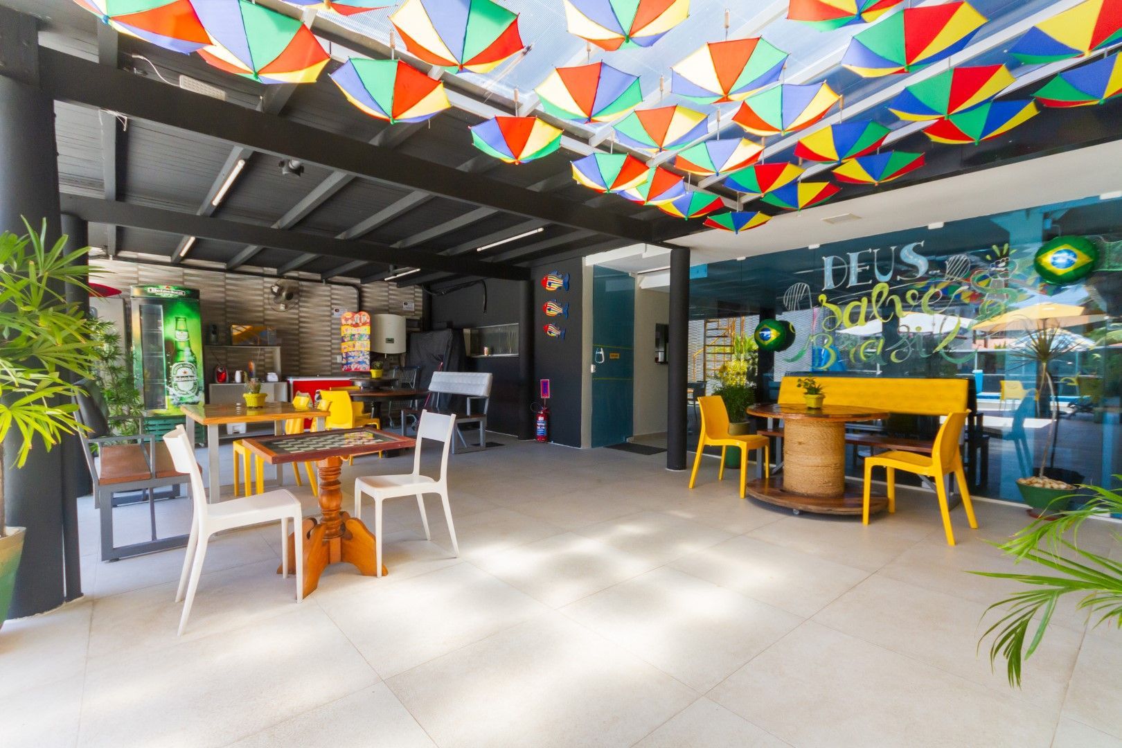 Uma sala com mesas, cadeiras e guarda-sóis pendurados no teto.