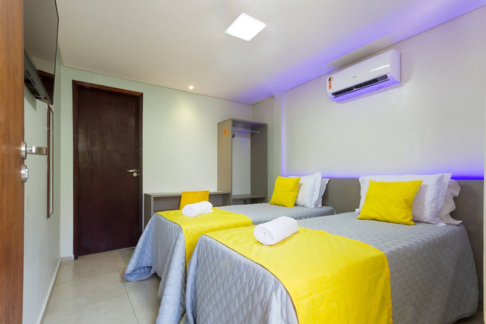 Um quarto de hotel com duas camas e uma televisão