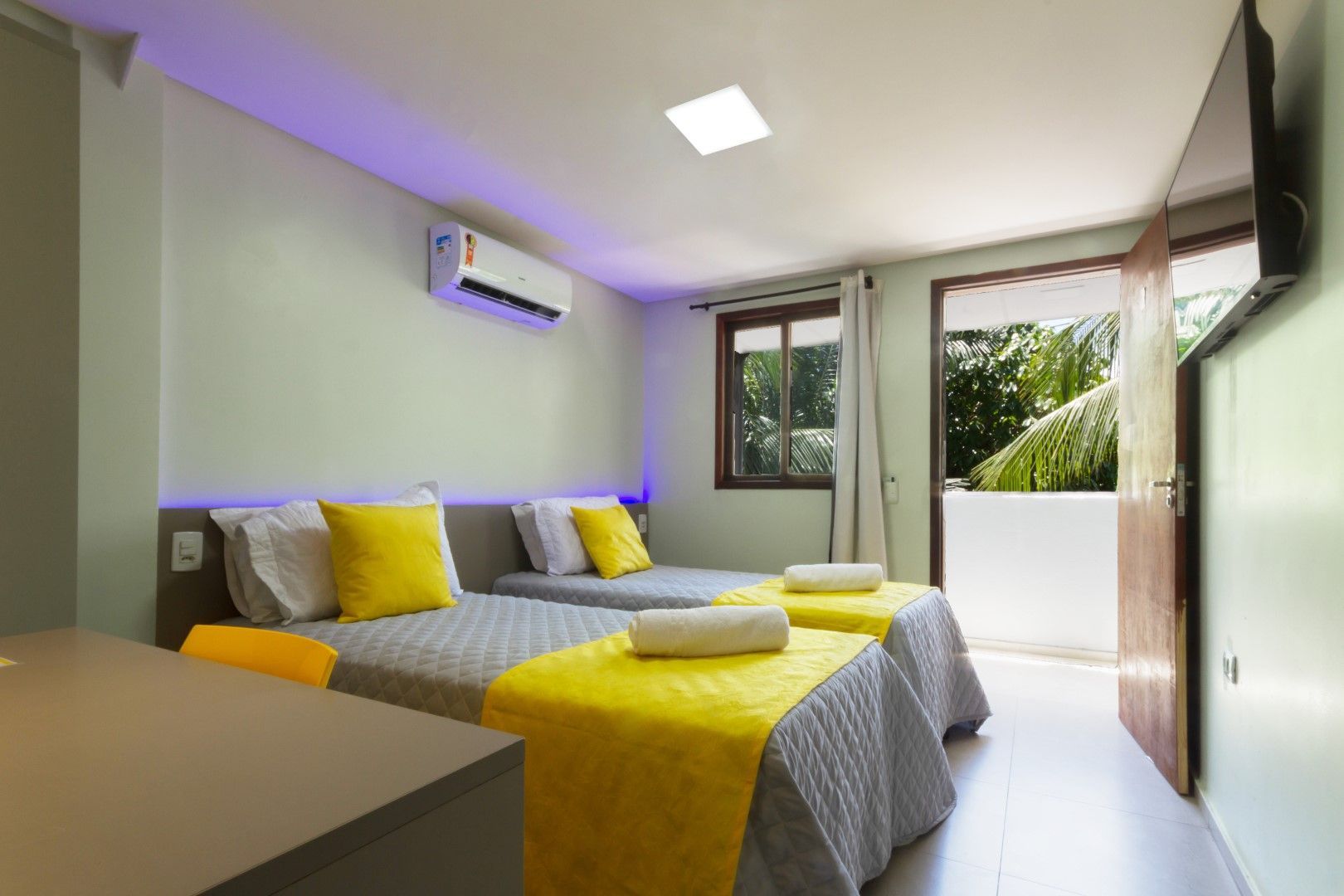 Um quarto de hotel com duas camas e uma TV de tela plana