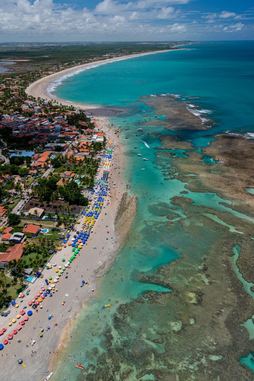 Uma vista aérea de uma praia com muitas pessoas.