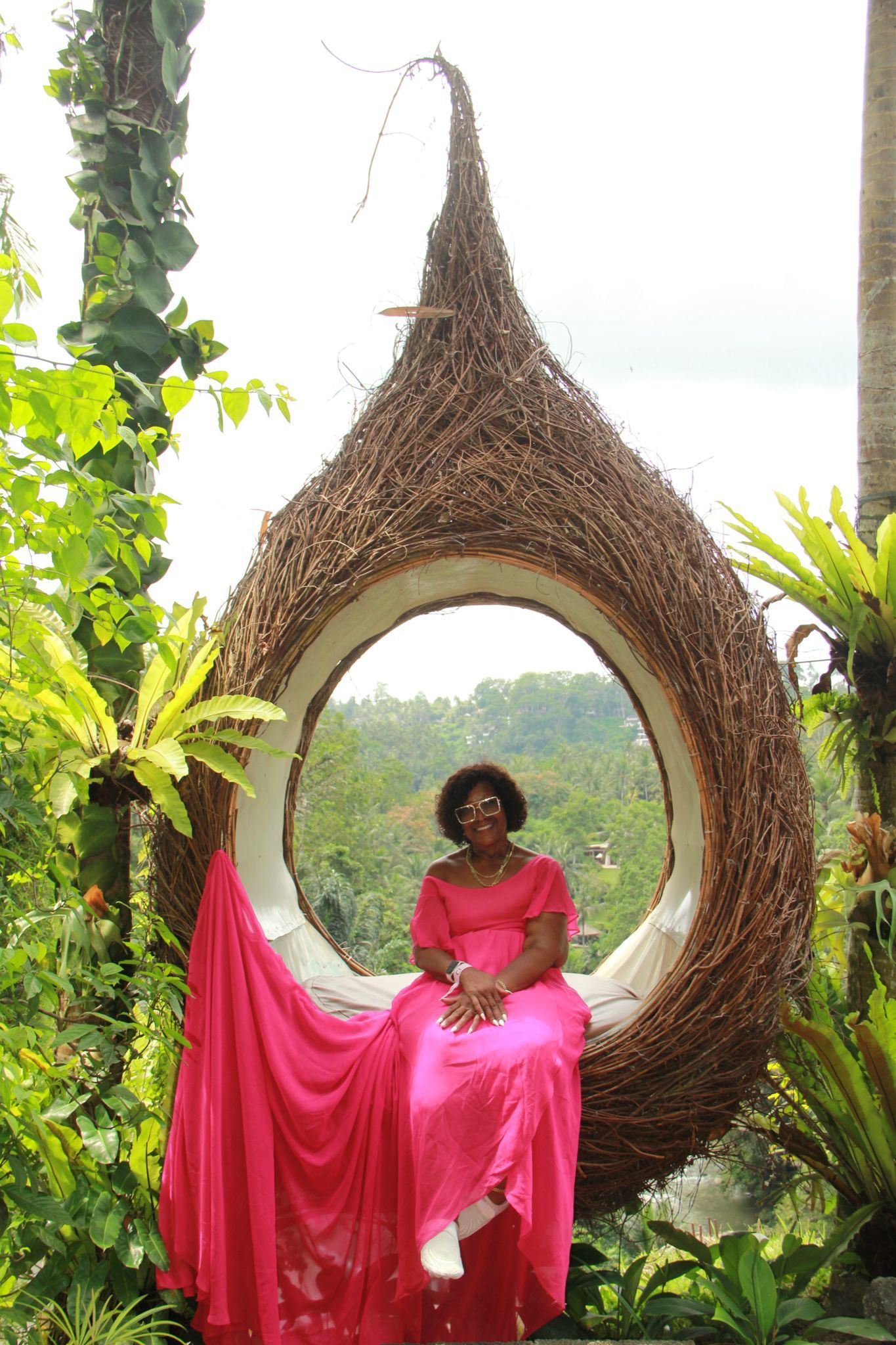 Traveler on Bali Swing soaring above Ubud rice terraces and tropical jungle