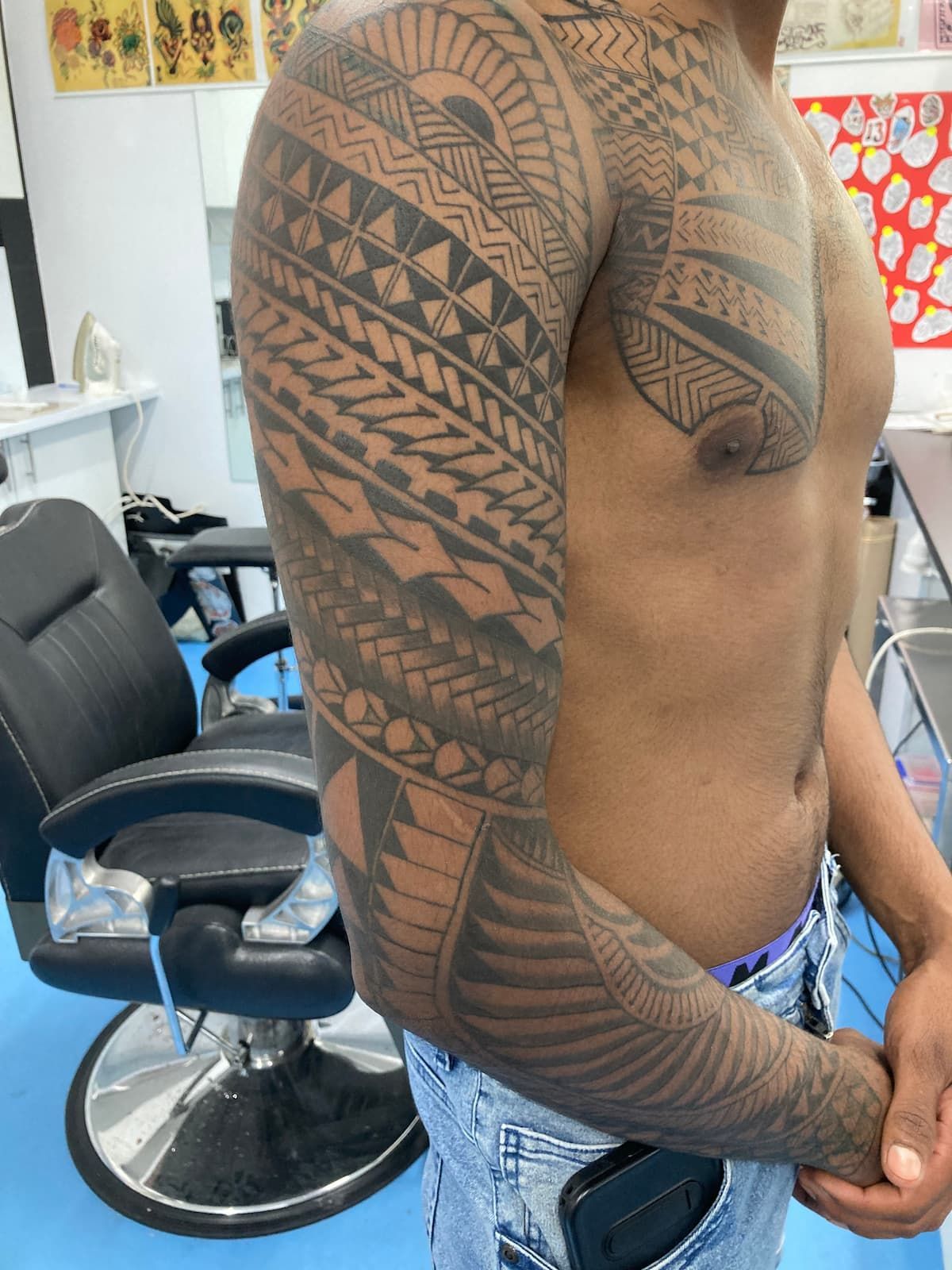 A Shirtless Man Has a Tattoo on His Arm and Chest — La Bomba Loca Tattoo in Cairns City, QLD
