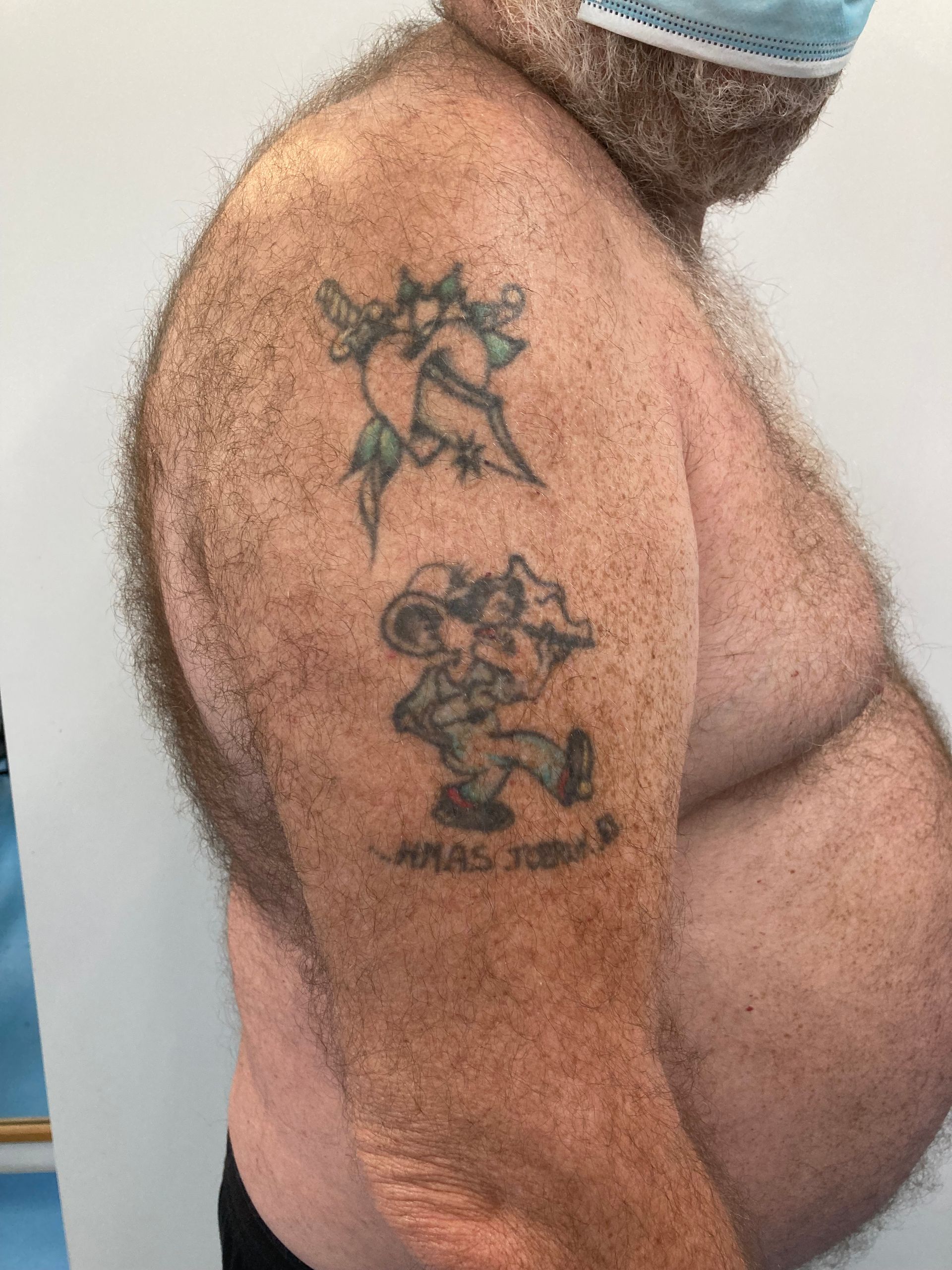 A Man With a Tattoo on His Arm is Wearing a Mask — La Bomba Loca Tattoo in Cairns City, QLD