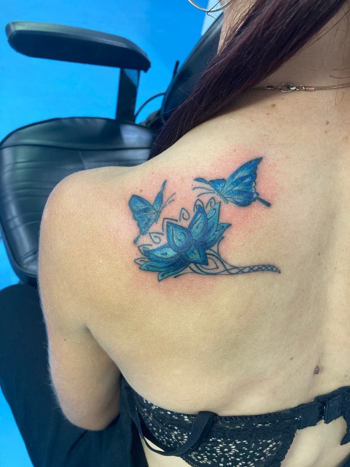 A Woman Has a Blue Butterfly Tattoo on Her Back — La Bomba Loca Tattoo in Cairns City, QLD