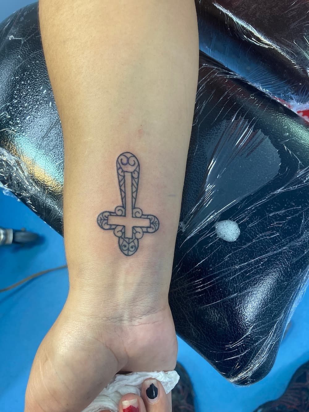 A Person Has a Tattoo of a Cross on Their Wrist — La Bomba Loca Tattoo in Cairns City, QLD