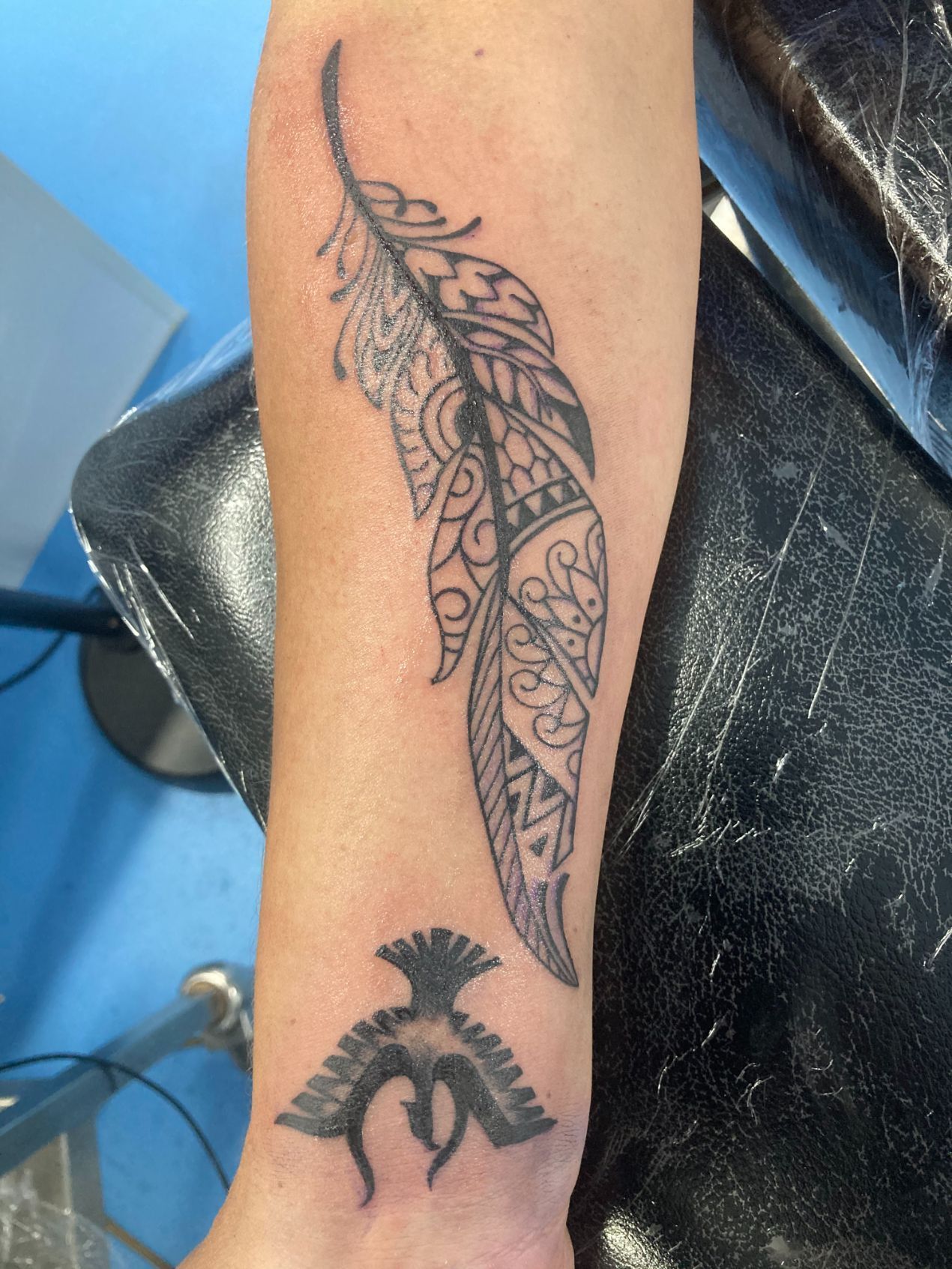 A Person Has a Tattoo of a Feather and a Bird on Their Arm — La Bomba Loca Tattoo in Cairns City, QLD