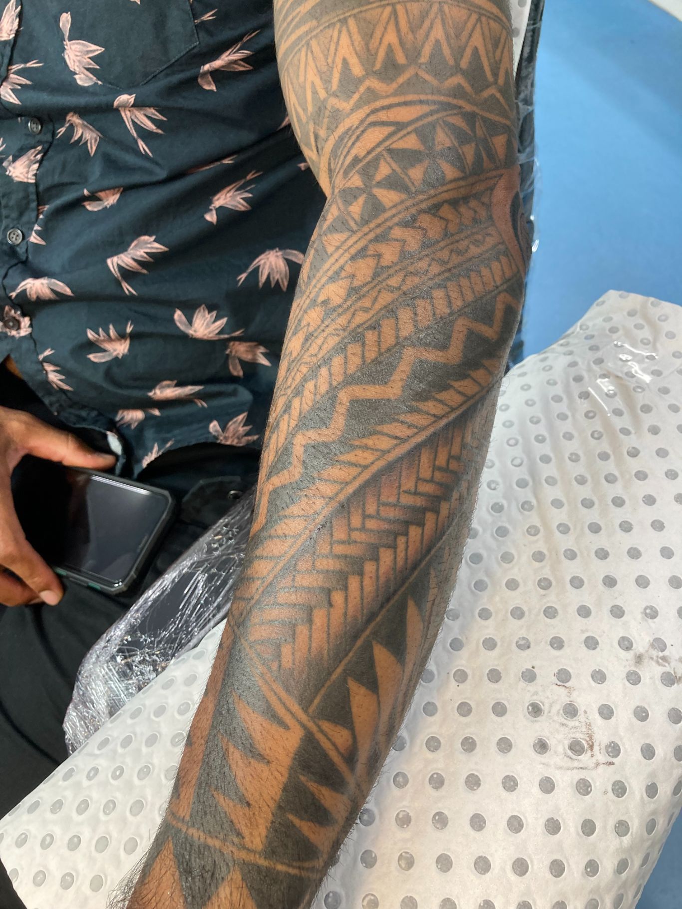 A Man With a Tattoo on His Arm is Holding a Cell Phone — La Bomba Loca Tattoo in Cairns City, QLD
