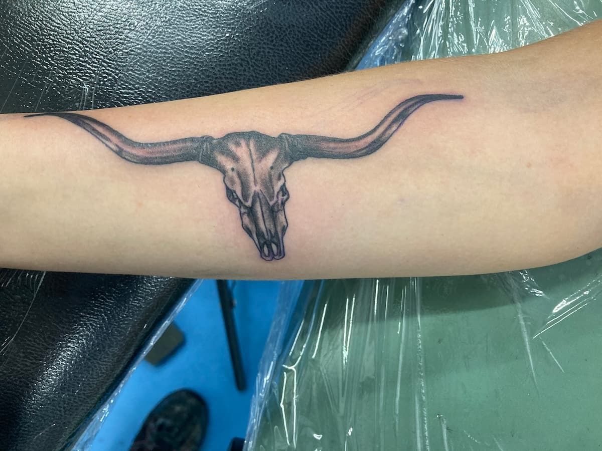 A Person Has a Tattoo of a Bull Skull on Their Arm — La Bomba Loca Tattoo in Cairns City, QLD