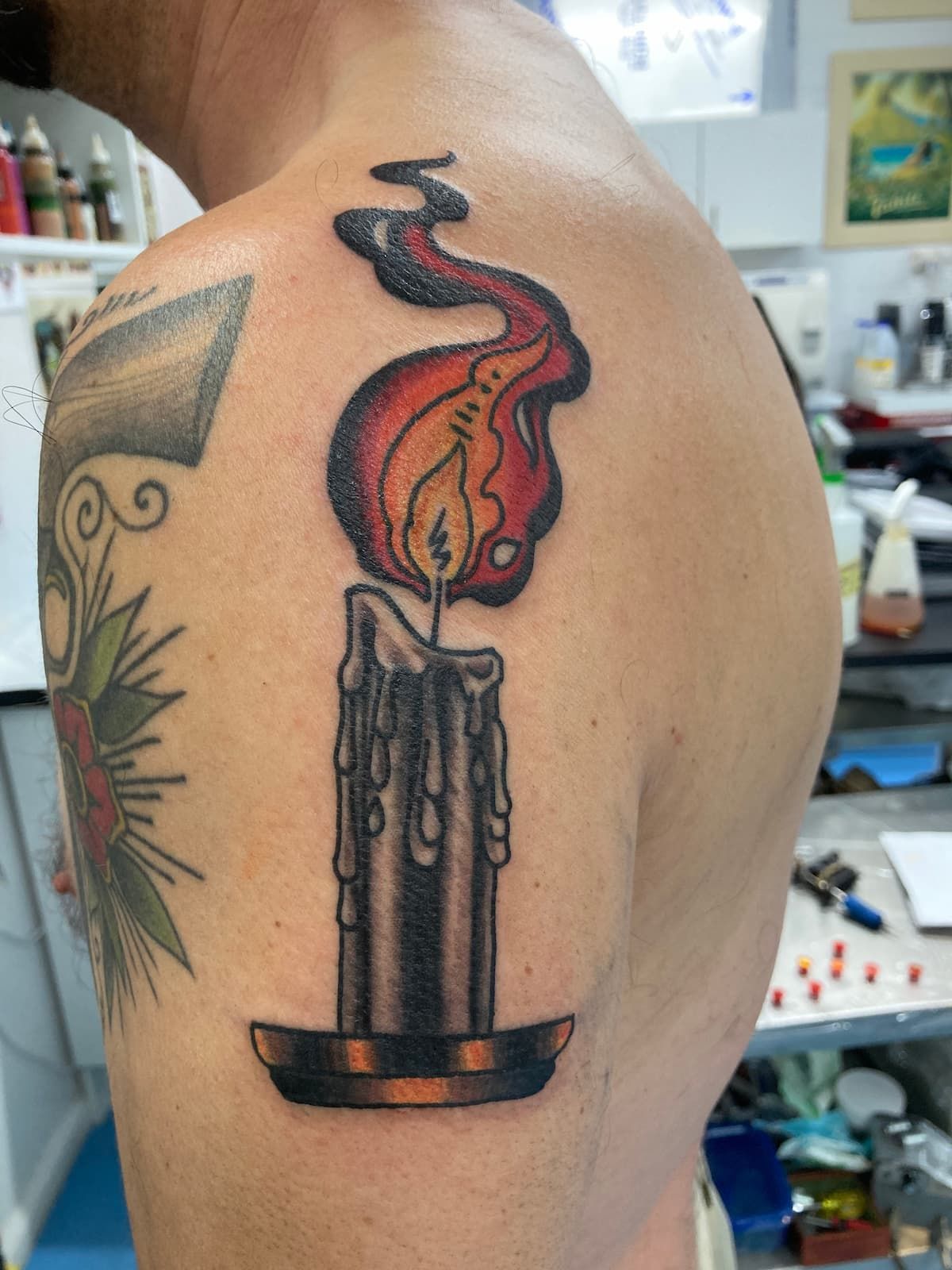 A Man Has a Tattoo of a Lit Candle on His Shoulder — La Bomba Loca Tattoo in Cairns City, QLD