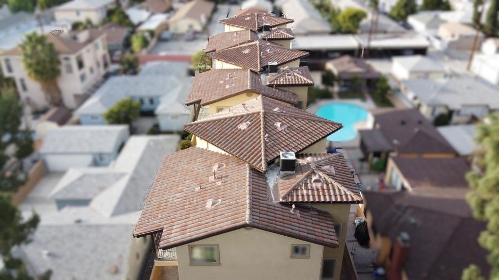 Row of houses with brown tile roofs, aerial view.