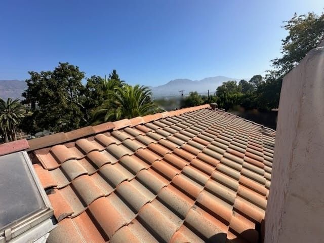 Clay tile roof overlooking a hazy mountain landscape.