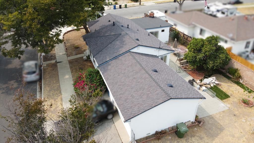 An aerial view of a row of houses with dark gray roofs.