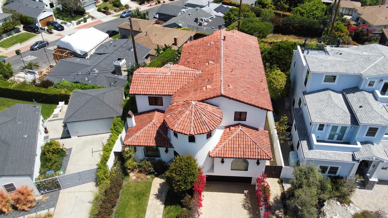 Aerial view of a Spanish-style home with red-tiled roof in a residential neighborhood.