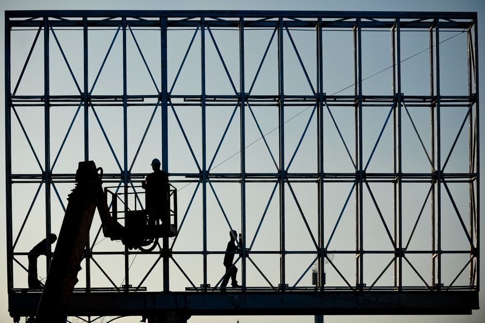 Three Workers in Silhouette Installing the Digital Advertising Billboard — Knowledgeable Draftsman in Townsville, QLD