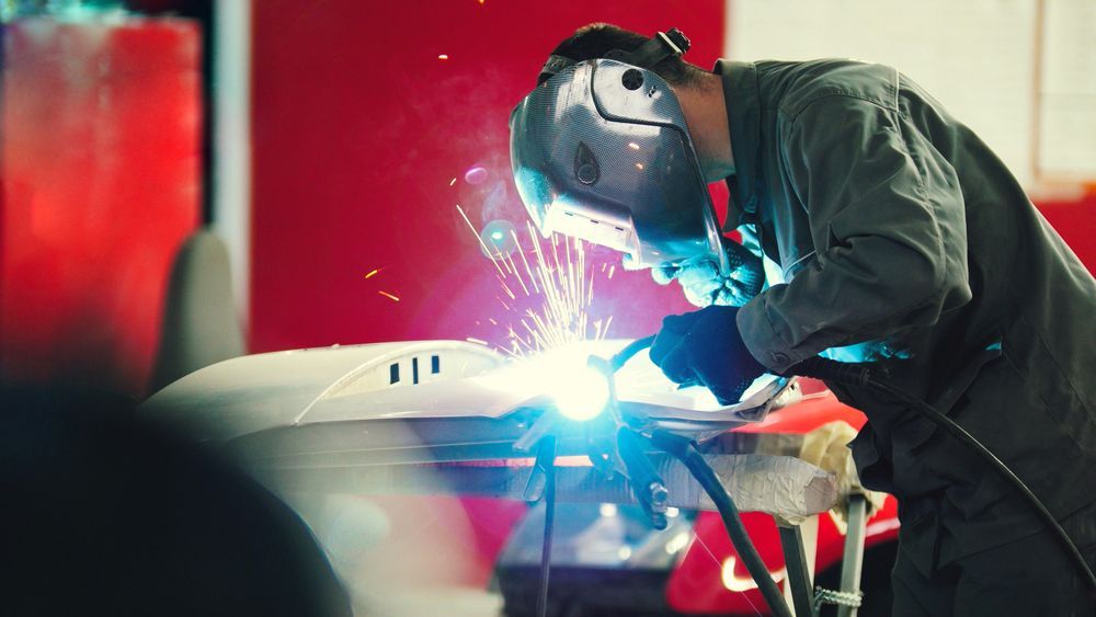 Welding Industrial Worker in Helmet Repair Detail in Car Auto Service — Qualified Steel Fabricators in Cairns, QLD