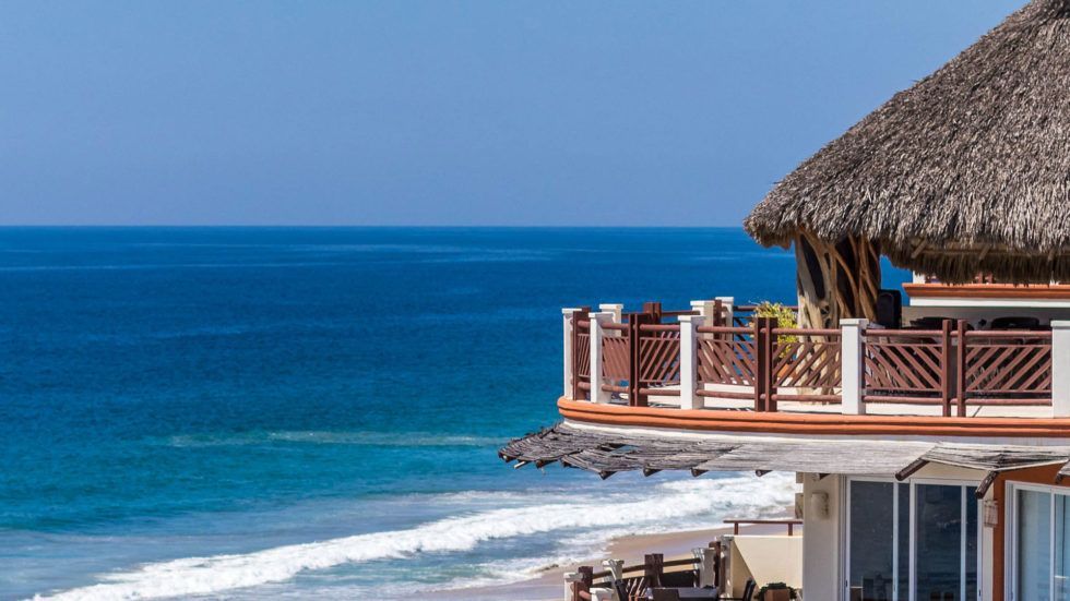 Ocean view from Vivo Clubhouse with a thatched roof; blue water and sky.