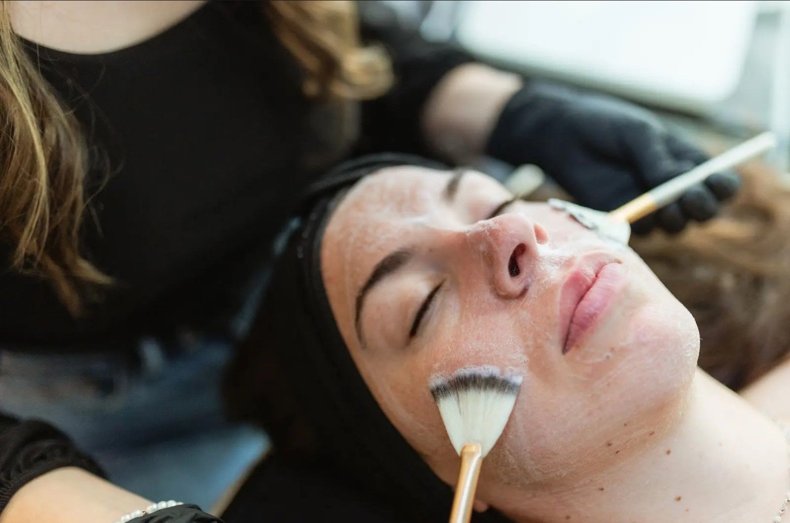 A woman is getting a facial treatment at a beauty salon.