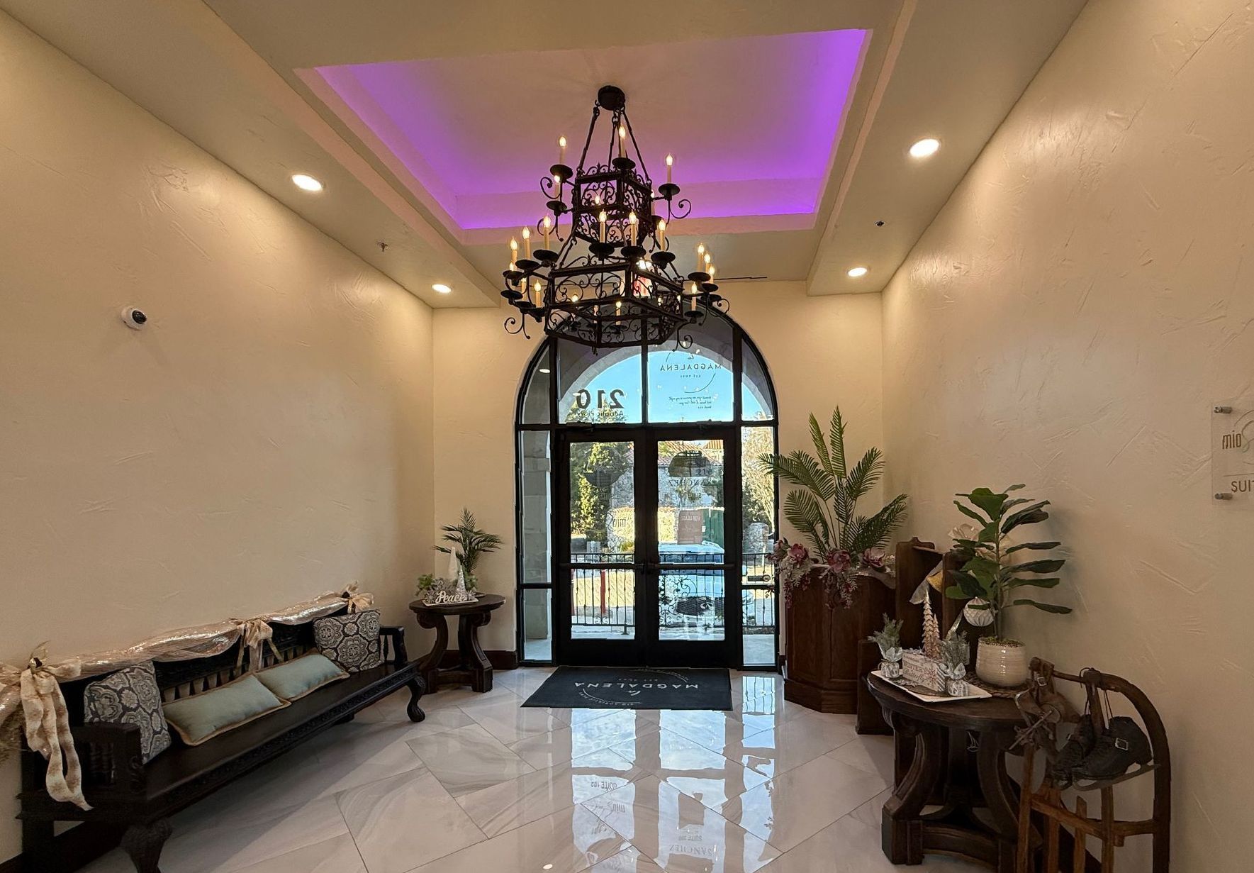A large room with a chandelier and a purple light on the ceiling.