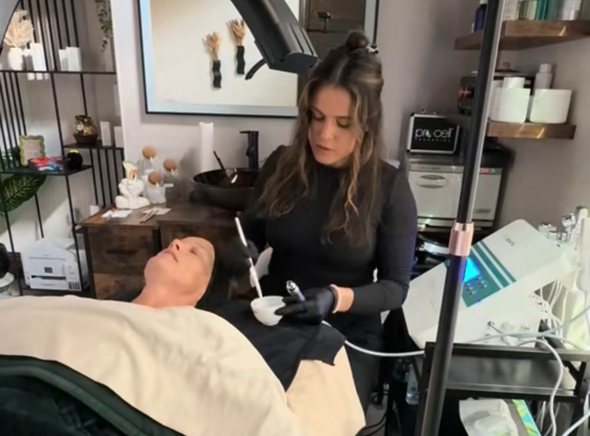 A woman is working on a man 's face in a beauty salon.