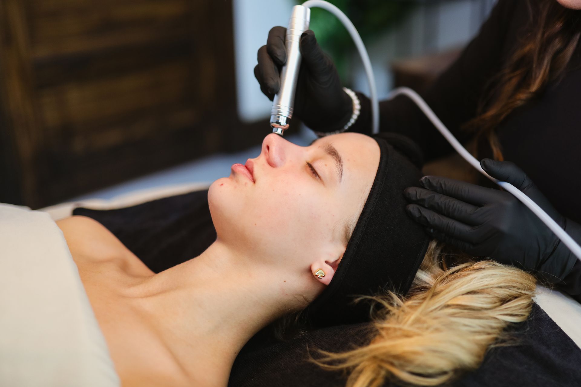 A woman is getting a facial treatment at a beauty salon. 