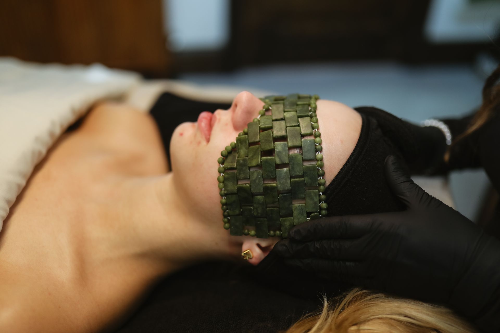 A woman is getting a facial treatment with a mask on her face.