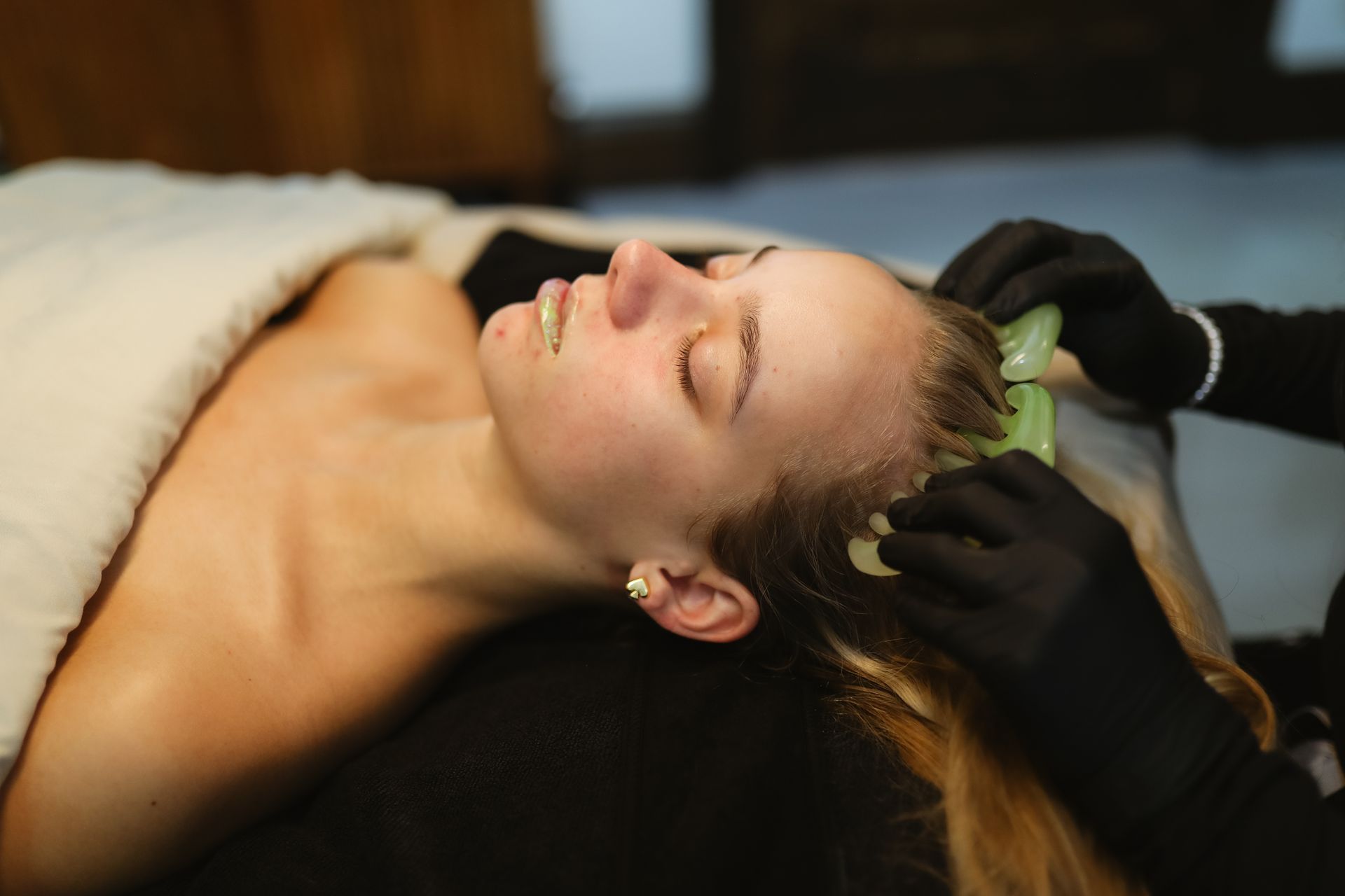 A woman is getting a head massage at a spa.
