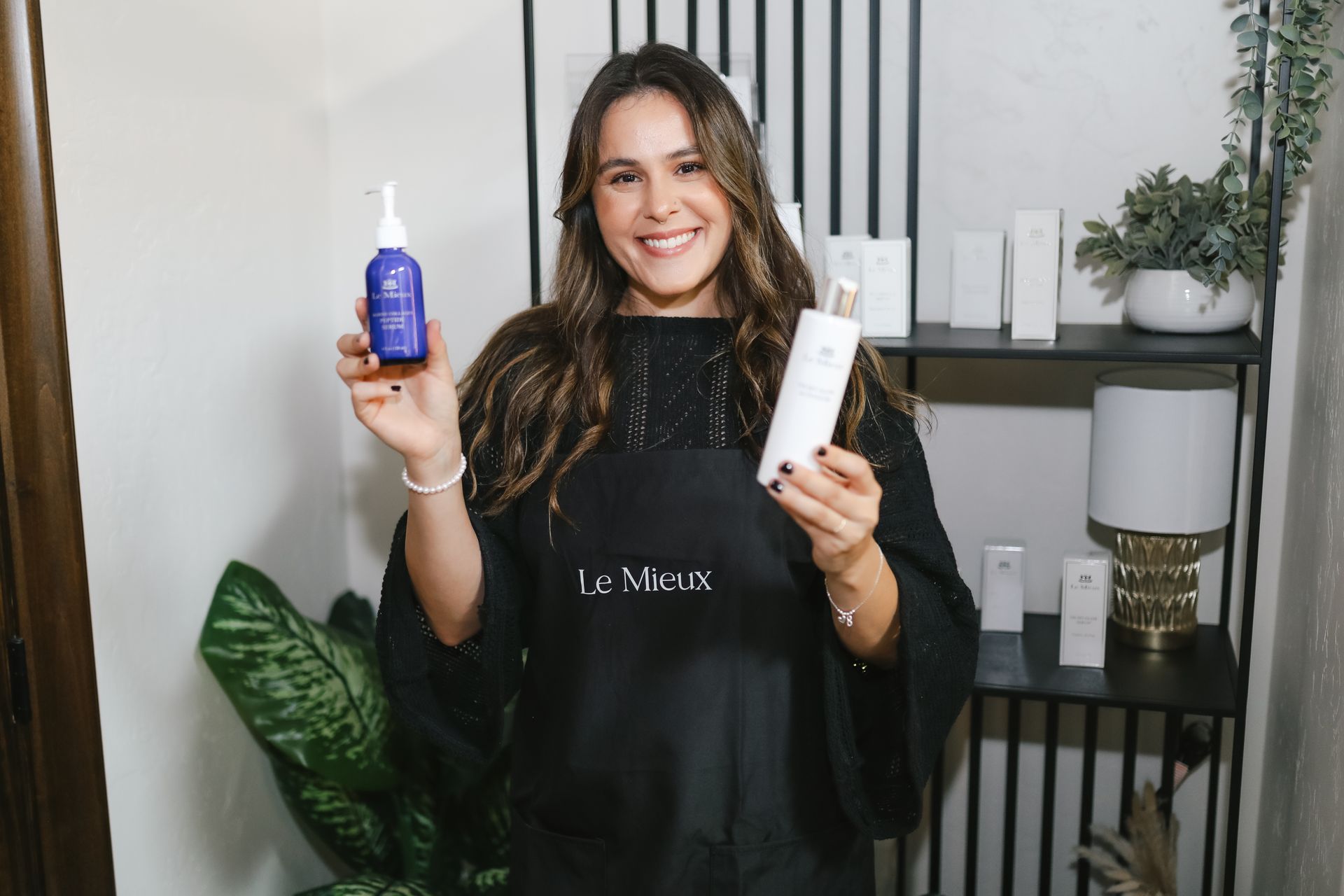 A woman is holding a bottle of shampoo and a bottle of lotion.