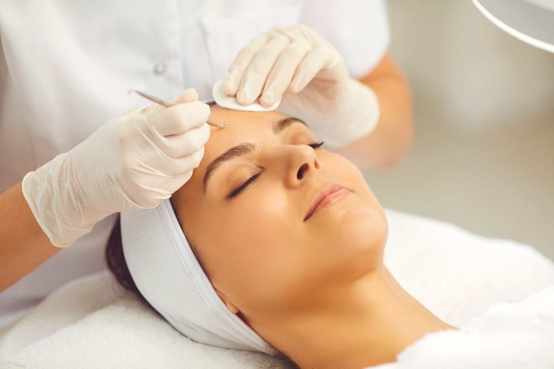 A woman is getting a facial treatment at a beauty salon.