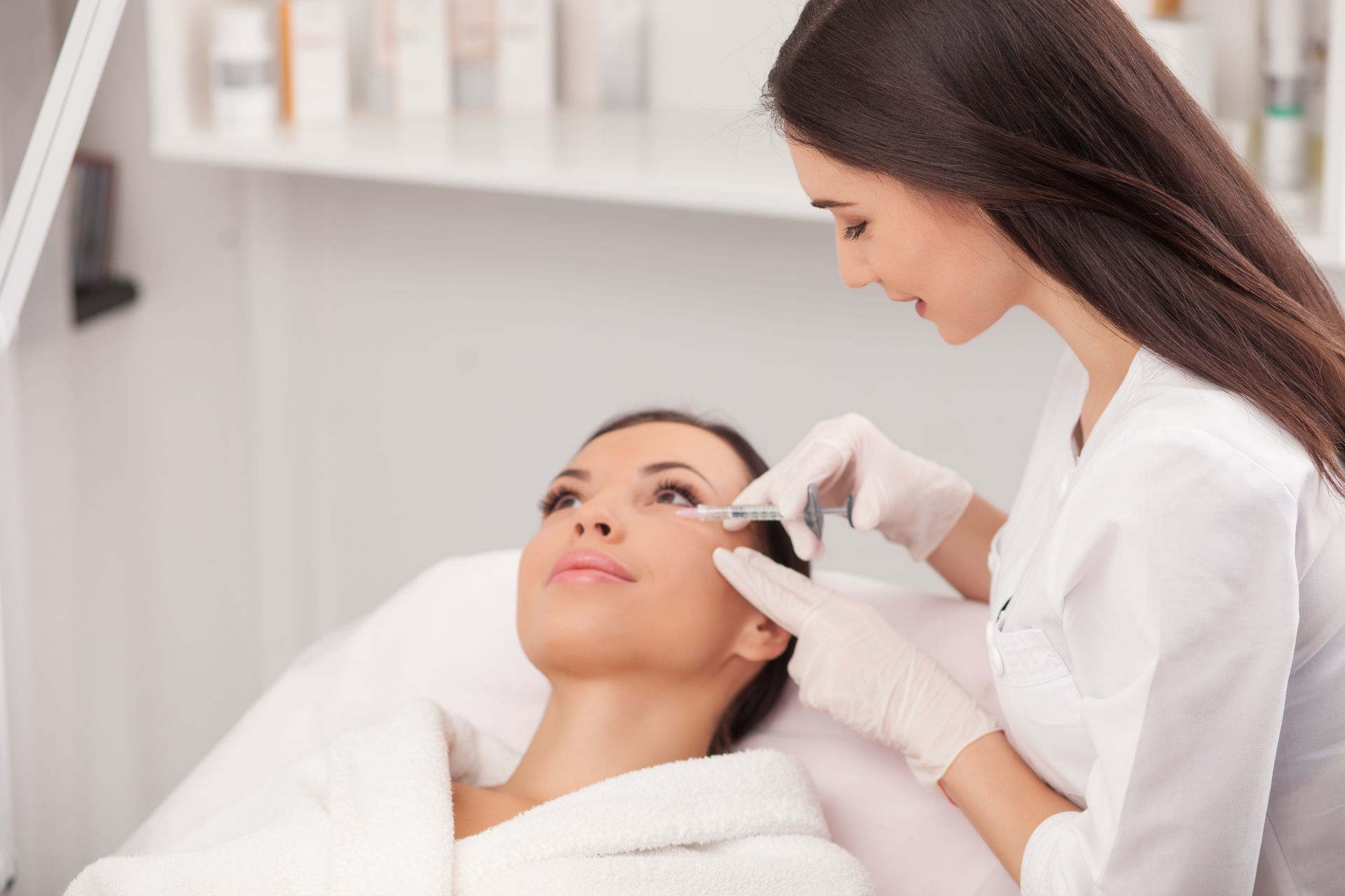 A woman is getting an injection in her face at a beauty salon.