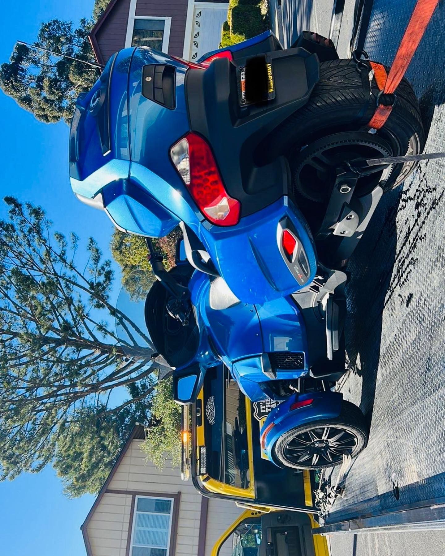 A blue motorcycle is being towed by a tow truck.