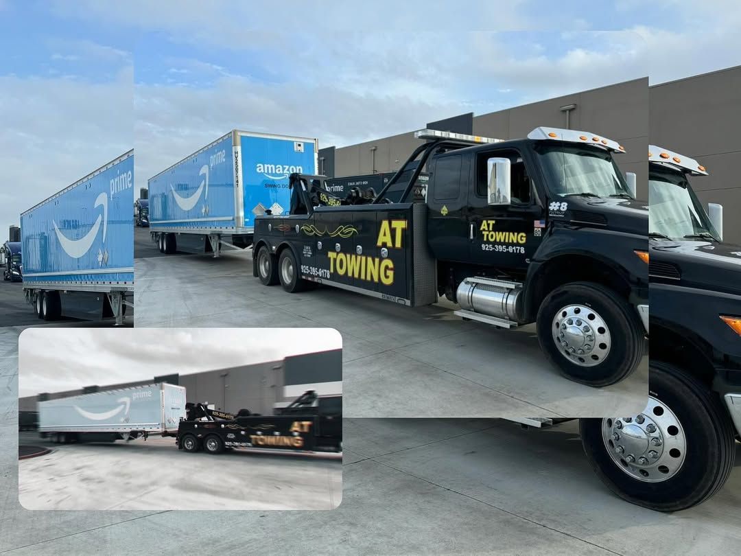 A tow truck is towing a semi truck in a parking lot.