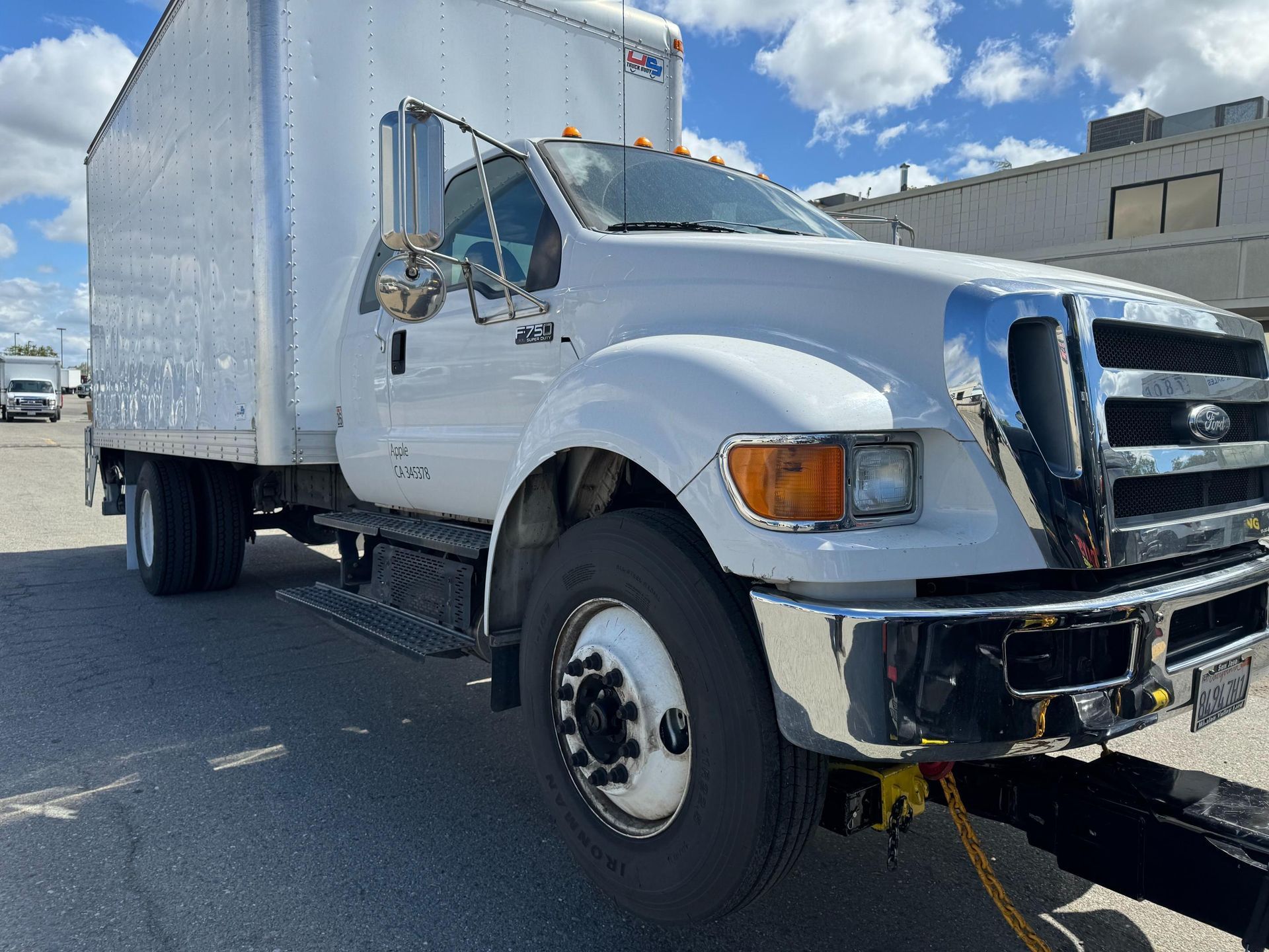 A white box truck is parked on the side of the road.