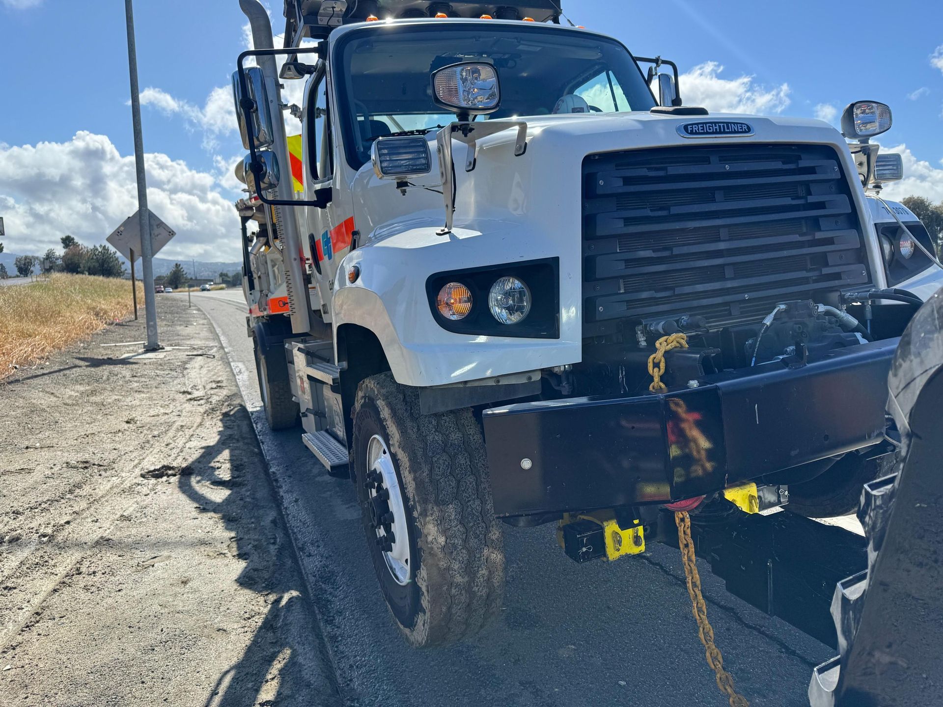 A white truck is parked on the side of the road.