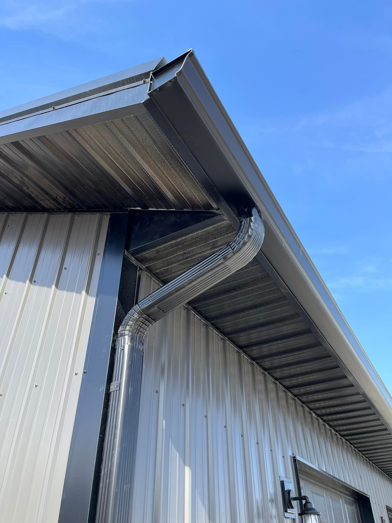 A close up of a gutter on the side of a building.