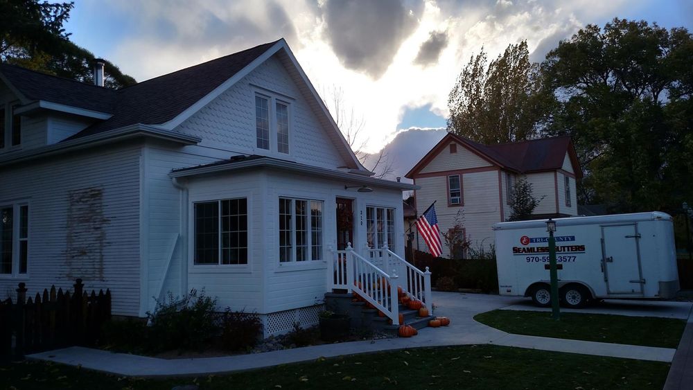 A white house with a white trailer parked in front of it