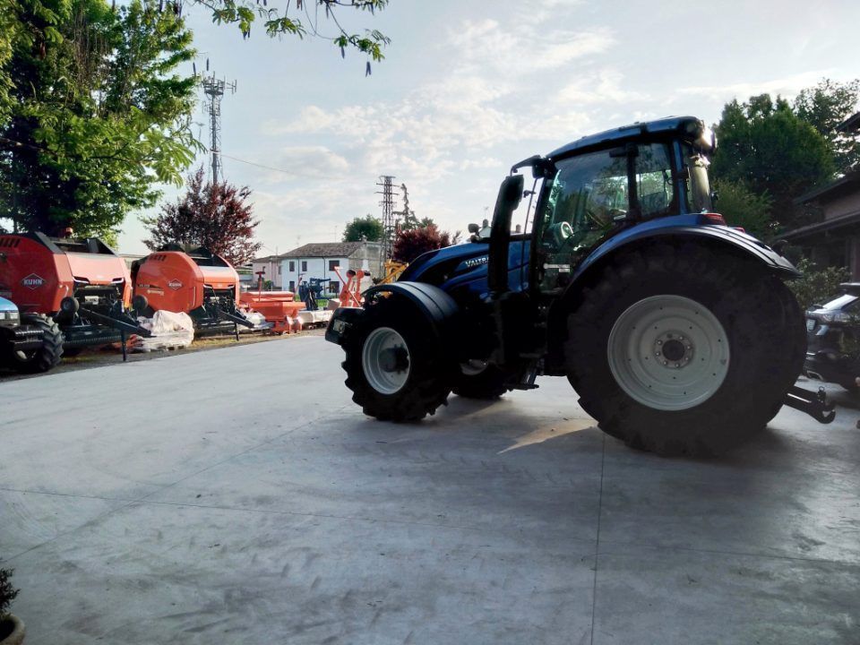 Un trattore blu è parcheggiato in un parcheggio.